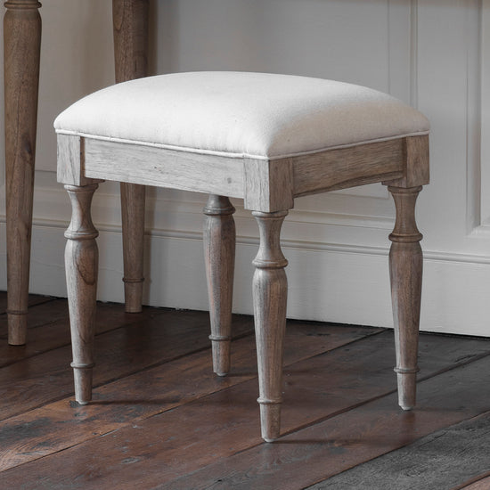 A Belsford Dressing Stool with a white upholstered seat, perfect for interior decor and home furniture enthusiasts.