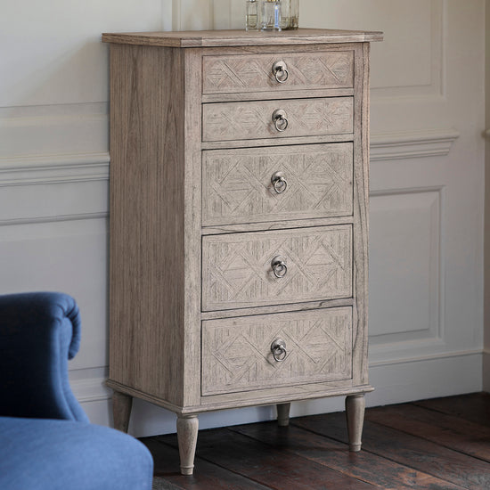 A Belsford 5 Drawer Lingerie Chest 600x450x1150mm by Kikiathome.co.uk adds to the interior decor in a room with a blue chair.