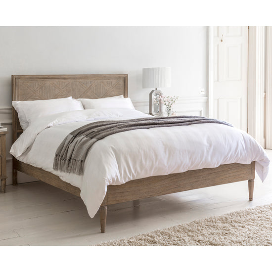 A Belsford 6' Bed with white sheets and a wooden headboard for interior decor.