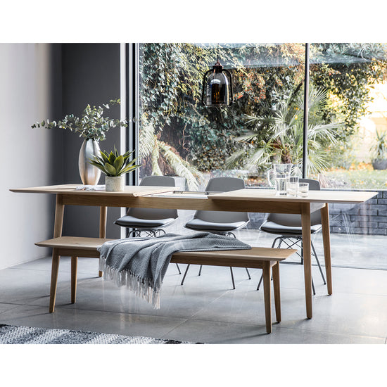 A modern dining room featuring the Tristford Extendable Dining Table and bench from Kikiathome.co.uk, showcasing stylish interior decor and home furniture.
