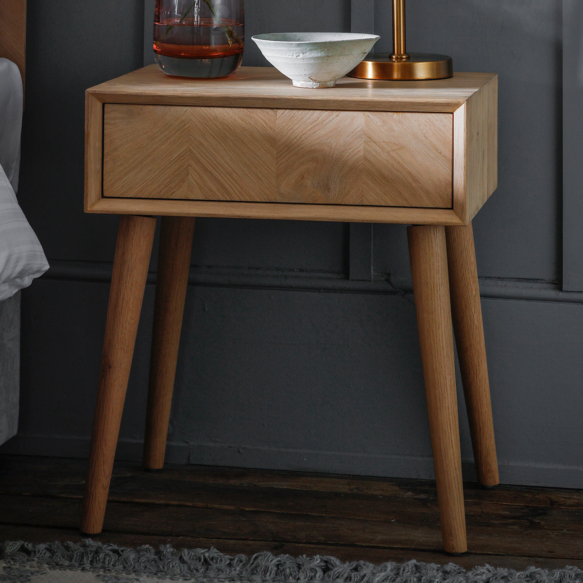A Tristford 1 Drawer Side Table by Kikiathome.co.uk for interior decor purposes with a lamp.