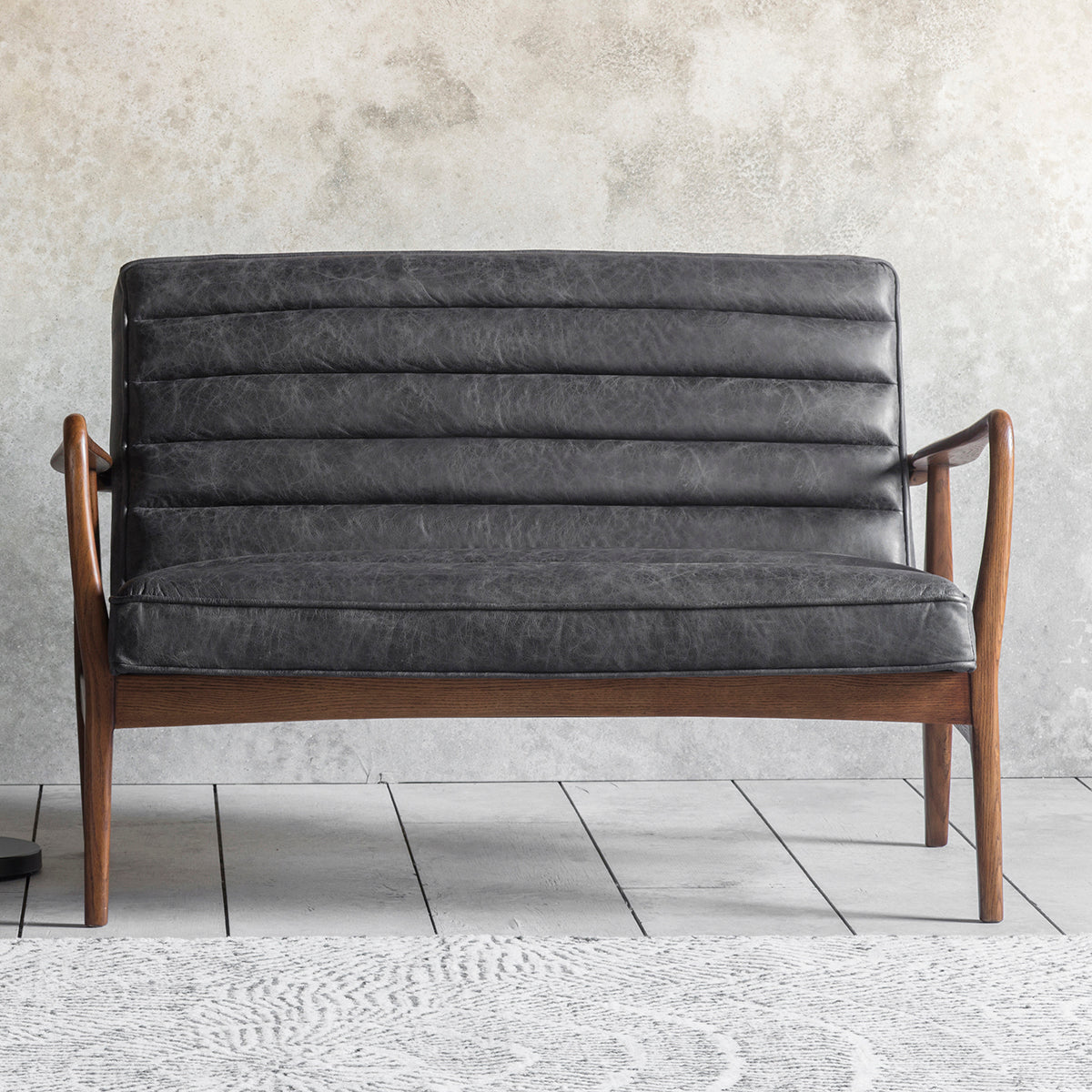 A Datsun 2 Seater Sofa Antique Ebony for home furniture and interior decor from Kikiathome.co.uk in front of a wall.