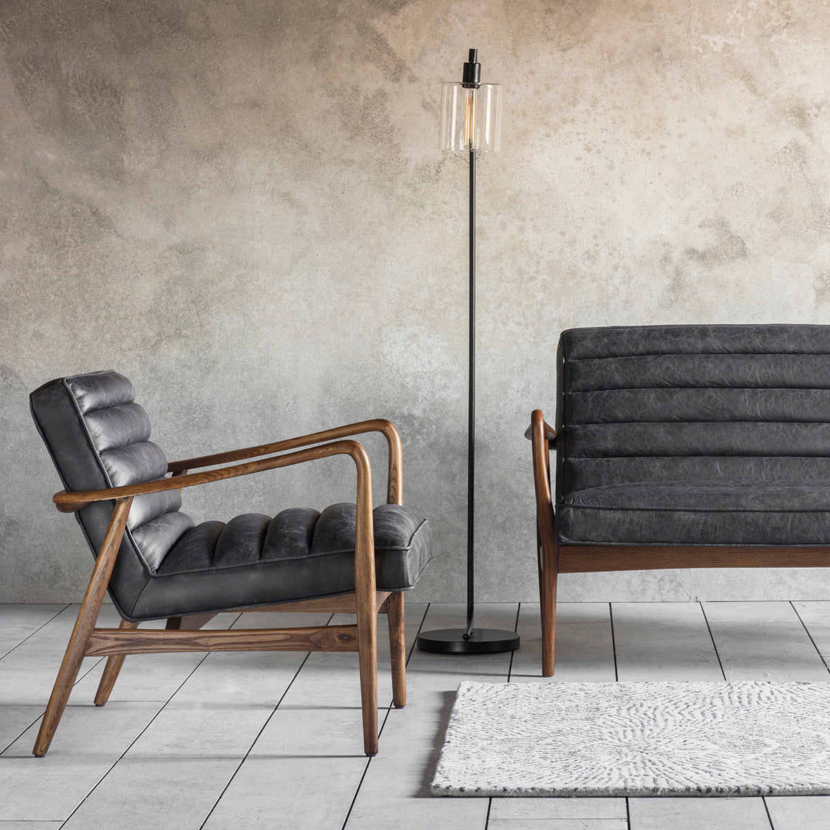 A pair of antique ebony chairs and a lamp on a concrete floor, part of Kikiathome.co.uk's interior decor collection.