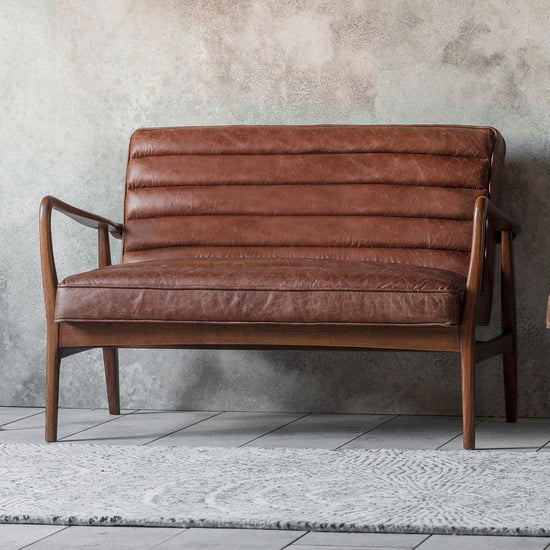 A vintage brown leather Datsun 2 seater sofa for interior decor and home furniture.