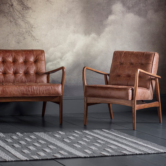 A pair of Vintage Brown Leather chairs for interior decor from Kikiathome.co.uk in front of a wall.