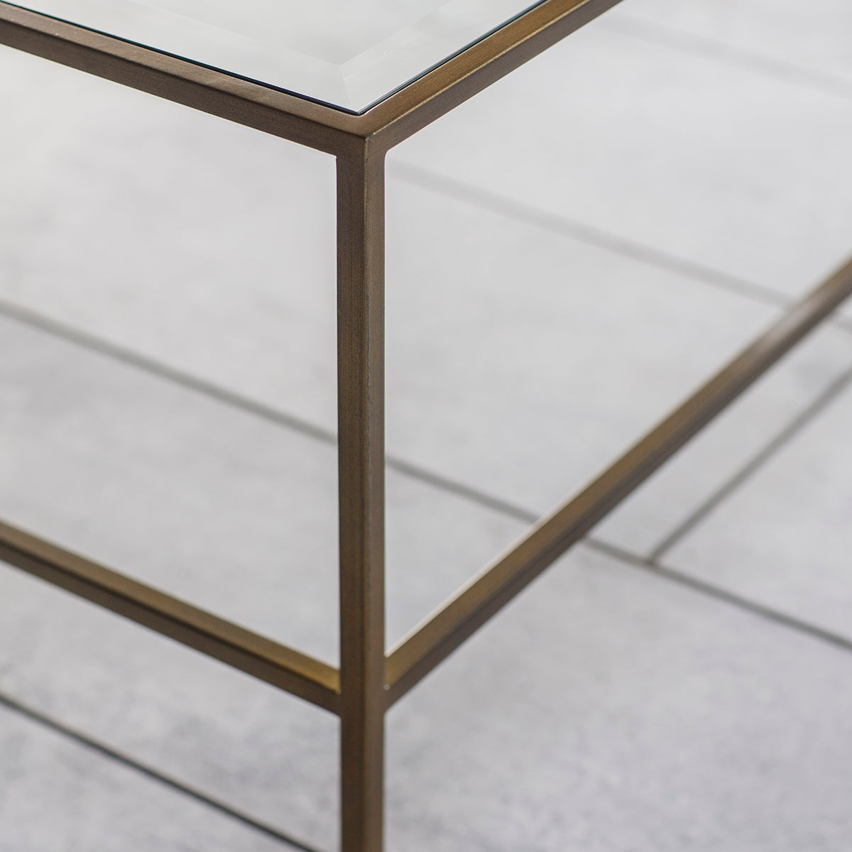 An Engleborne Coffee Table Bronze 1200x650x400mm with a brass frame and glass top, sold by Kikiathome.co.uk, perfect for interior decor.