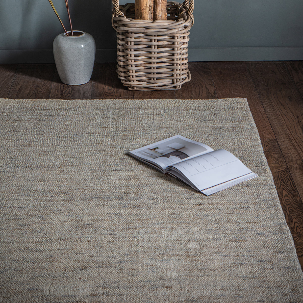 A Ford Rug from Kikiathome.co.uk enhances interior decor with its Champagne color and is placed on a wooden floor alongside a book.