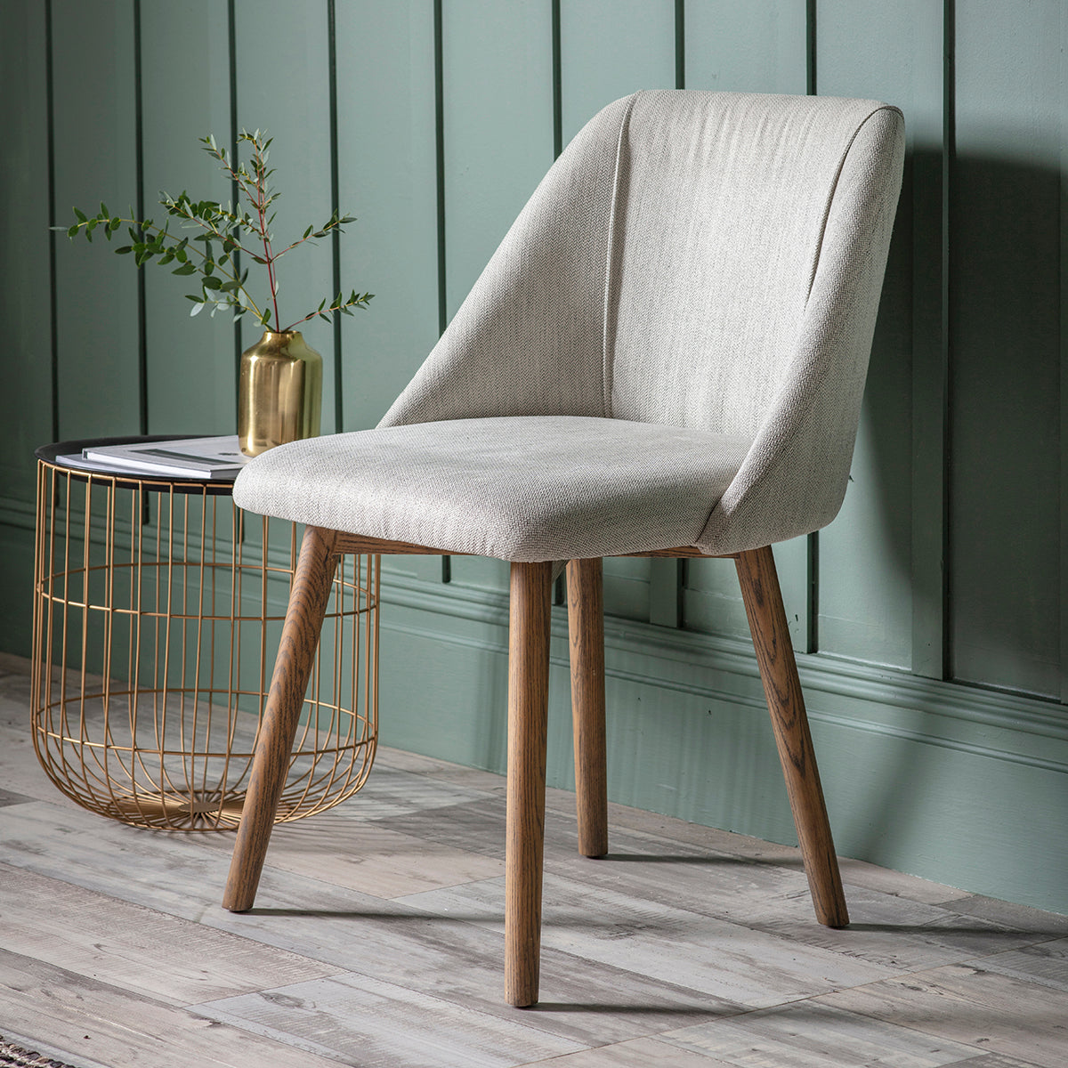 A Hempston Dining Chair Neutral (2pk) 570x610x840mm by Kikiathome.co.uk for interior decor with wooden legs in front of a green wall.