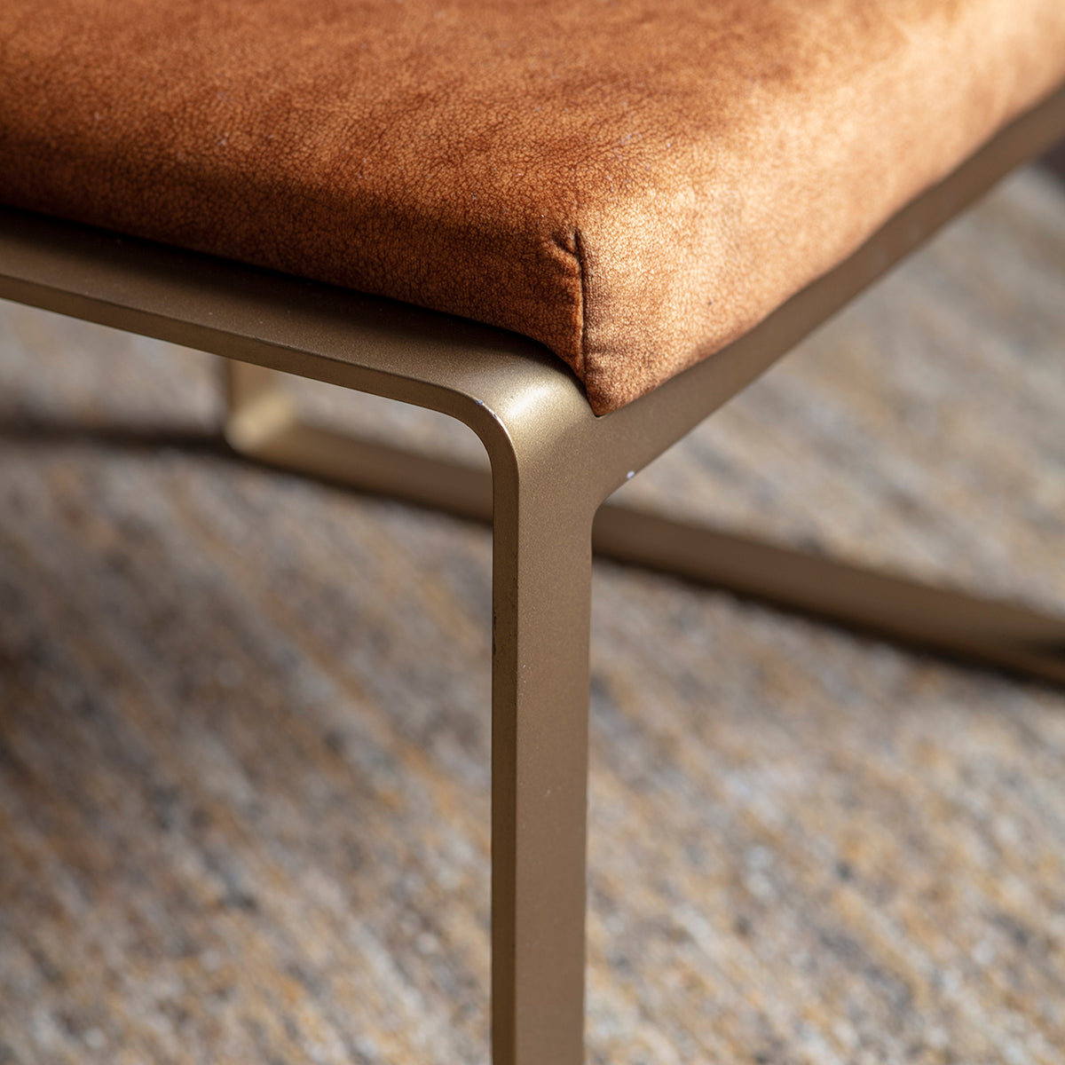 A Huish Footstool Ochre 500x430x360mm, perfect for interior decor, with a metal frame and a tan upholstered seat by Kikiathome.co.uk.