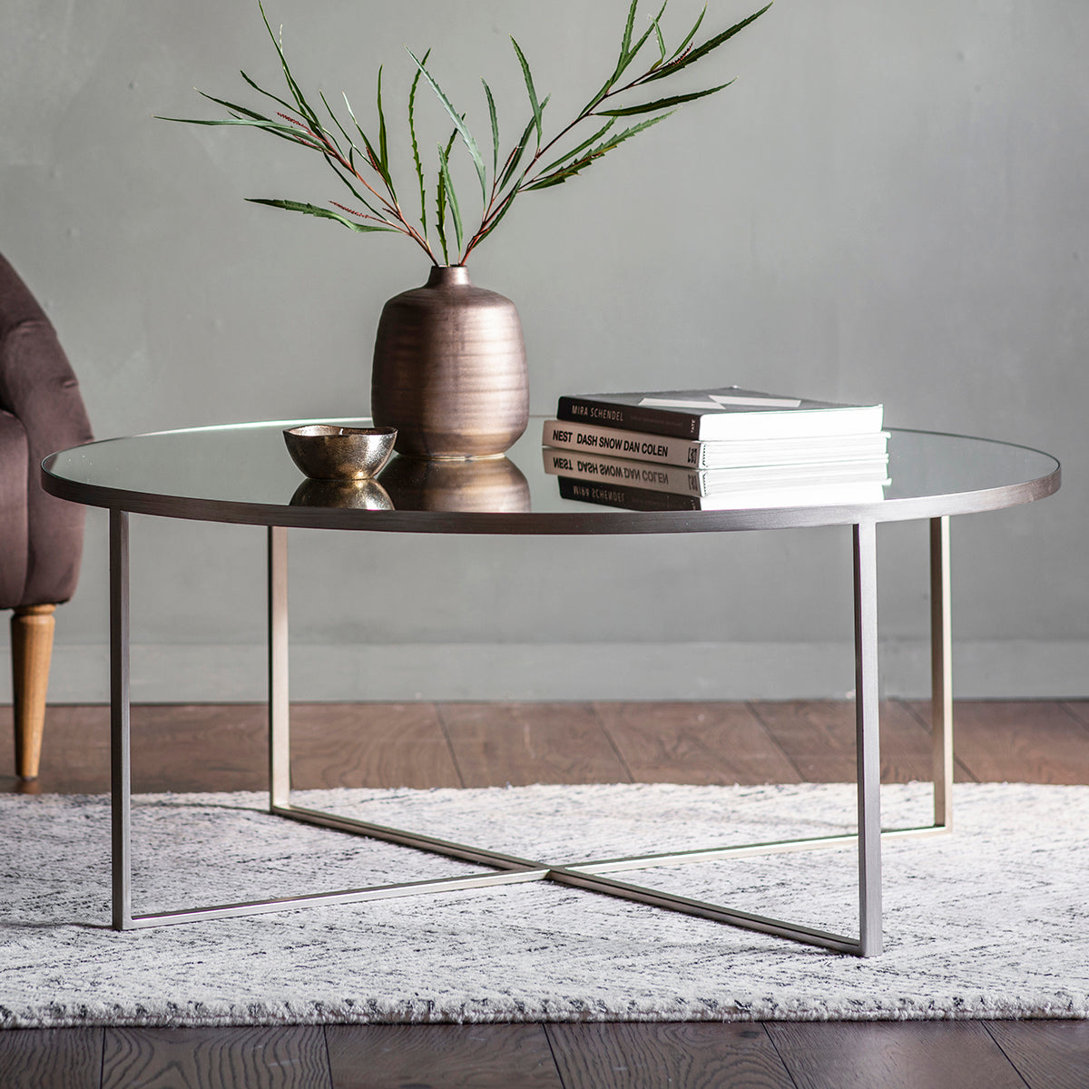 A Silver Torrance Coffee Table with a plant on top, perfect for home furniture and interior decor.
