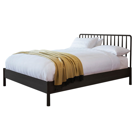 A Tigley 5' Spindle Bed Black from Kikiathome.co.uk, a stylish interior decor piece that combines a metal frame with a yellow blanket.