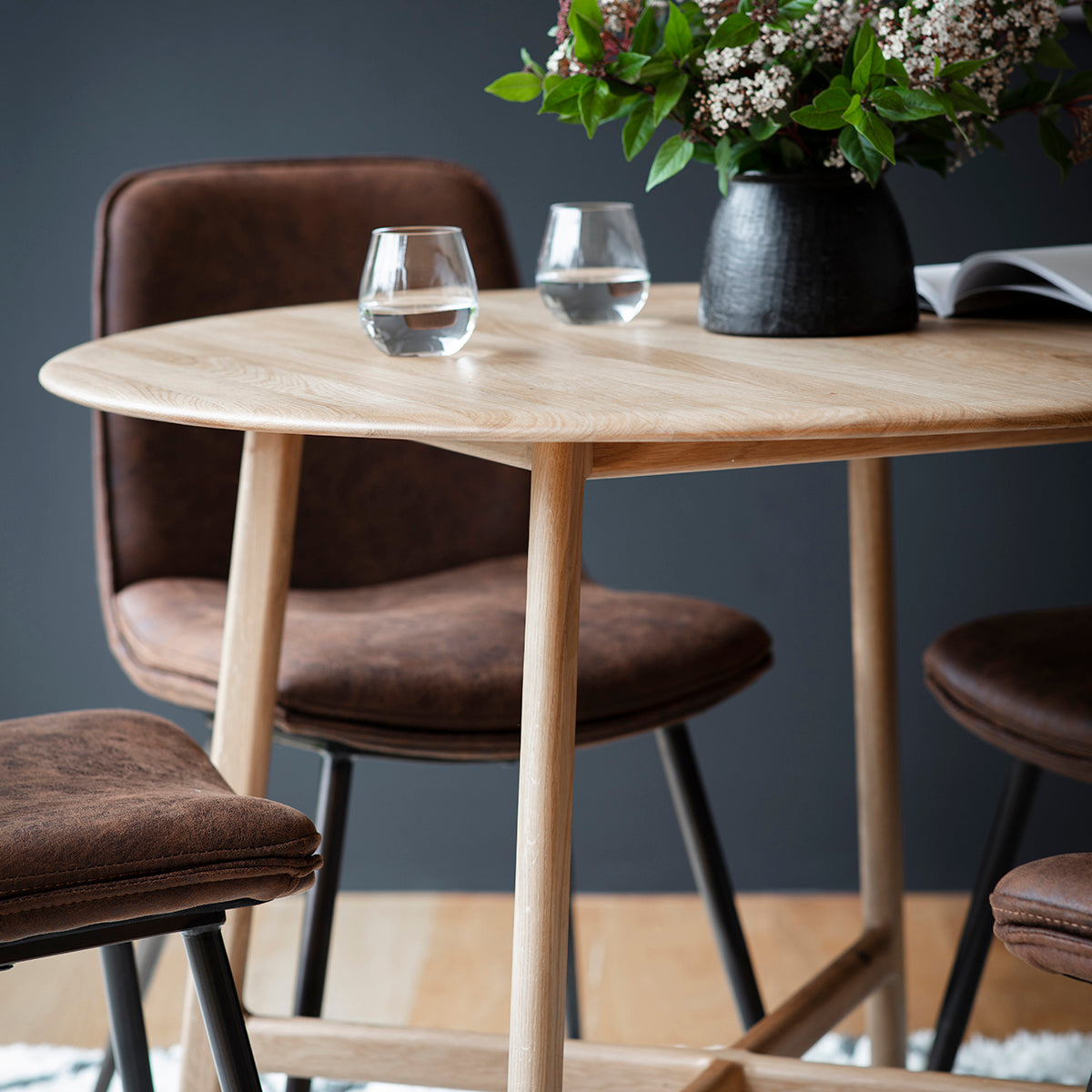 Load image into Gallery viewer, An interior decor essential, the Dairy Round Dining Table 1000x1000x750mm from Kikiathome.co.uk comes complete with four chairs and a vase.
