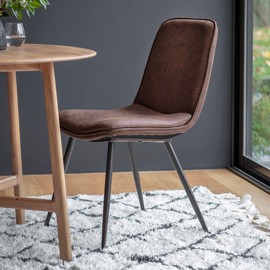 A Newton Chair Brown (2pk) from Kikiathome.co.uk as home furniture, next to a wooden table.