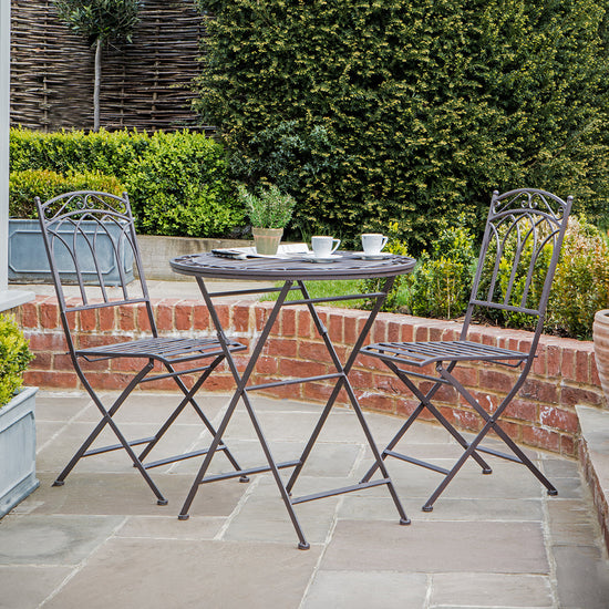 A stylish outdoor bistro set with a Rushford Ember table and chairs, perfect for your patio.