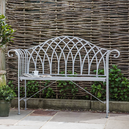 A white Noss Outdoor Bench Estate by Kikiathome.co.uk serving as home furniture in a garden.