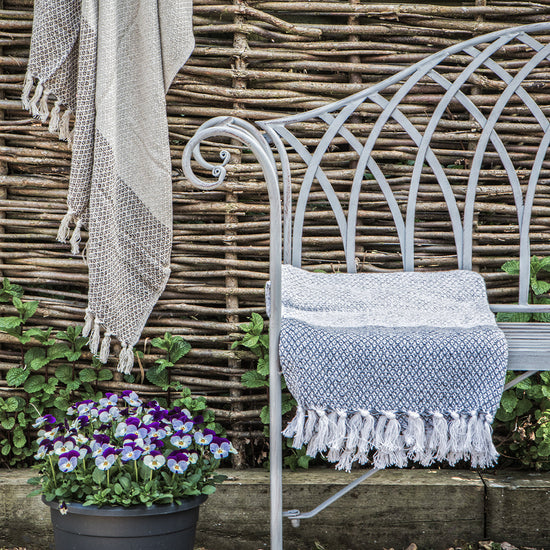 A Noss Outdoor Bench Estate from Kikiathome.co.uk, perfect for home furniture and interior decor, with a towel on it next to a potted flower.