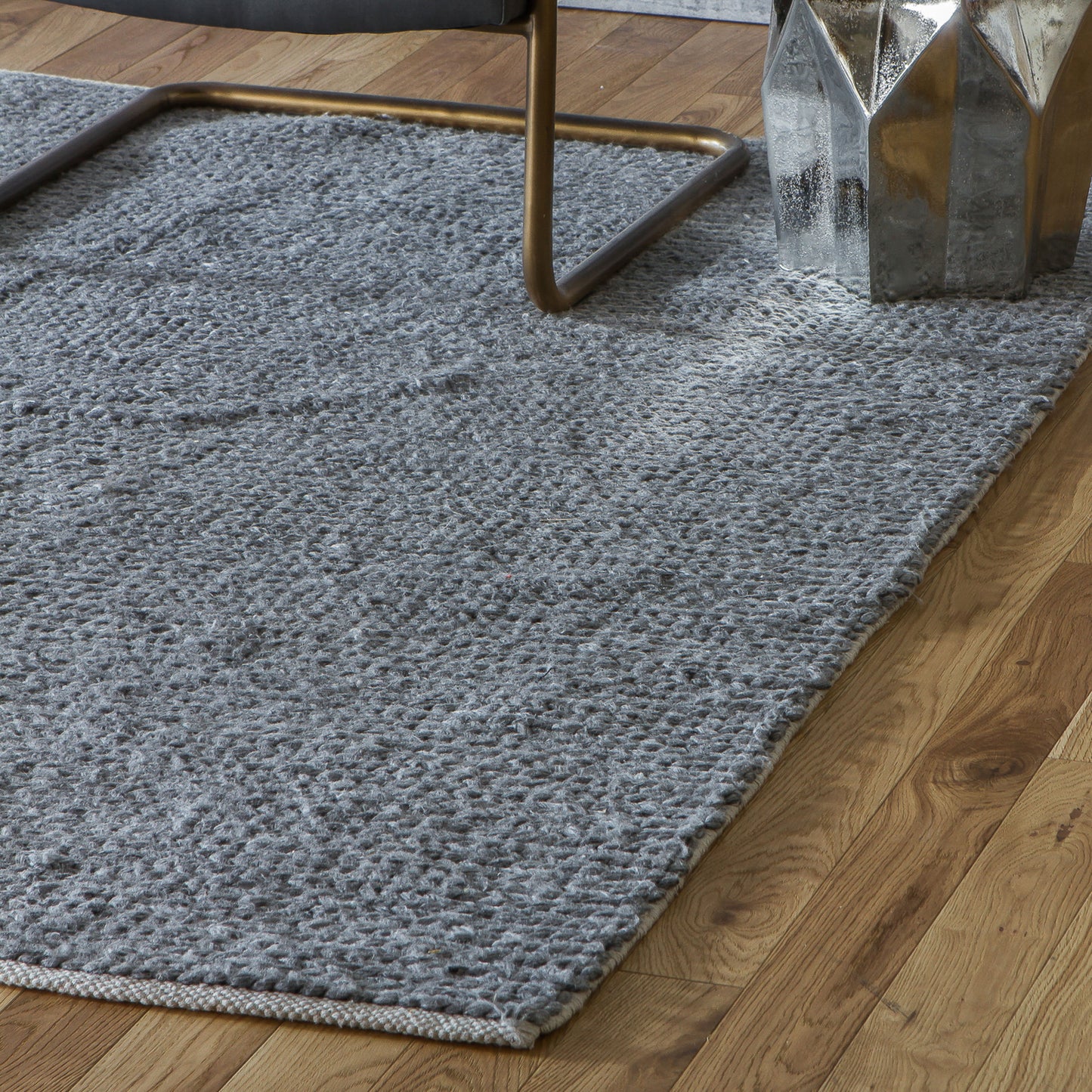 An Imperial Rug Grey 1600x2300mm from Kikiathome.co.uk, perfect for interior decor on a wooden floor.