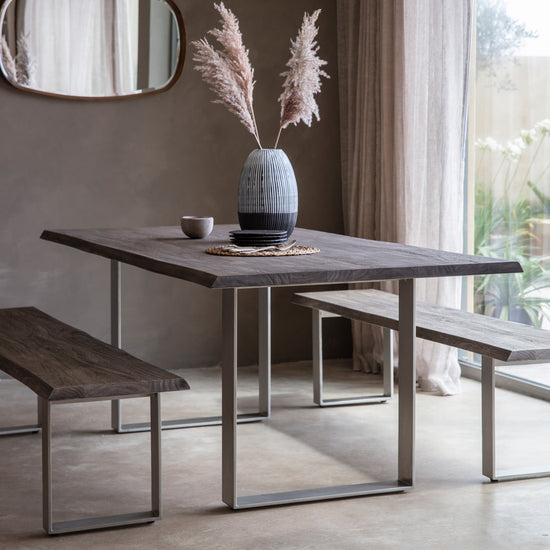 A grey dining table set with benches and mirror for stylish interior decor from Kikiathome.co.uk.