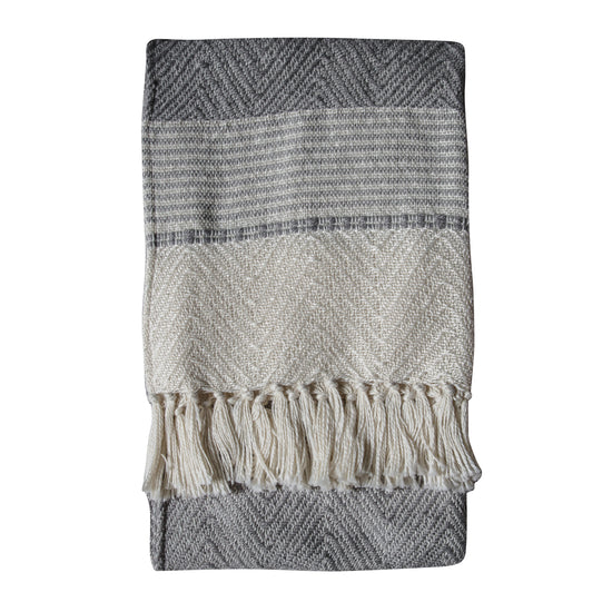 A Chevron Grey Throw with fringes for home interior decor.