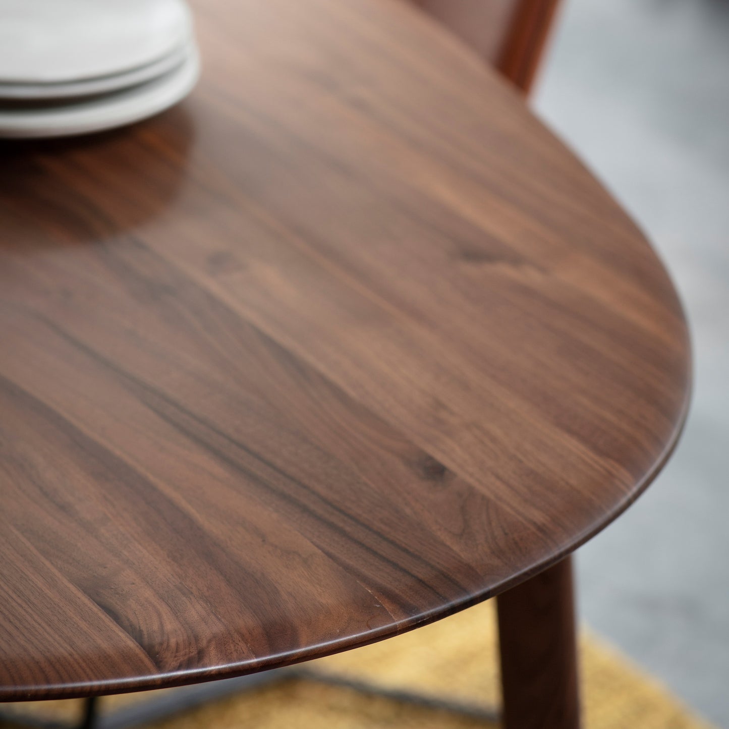 A close up of a Walnut oval dining table from Kikiathome.co.uk with plates on it, perfect for interior decor and home furniture.