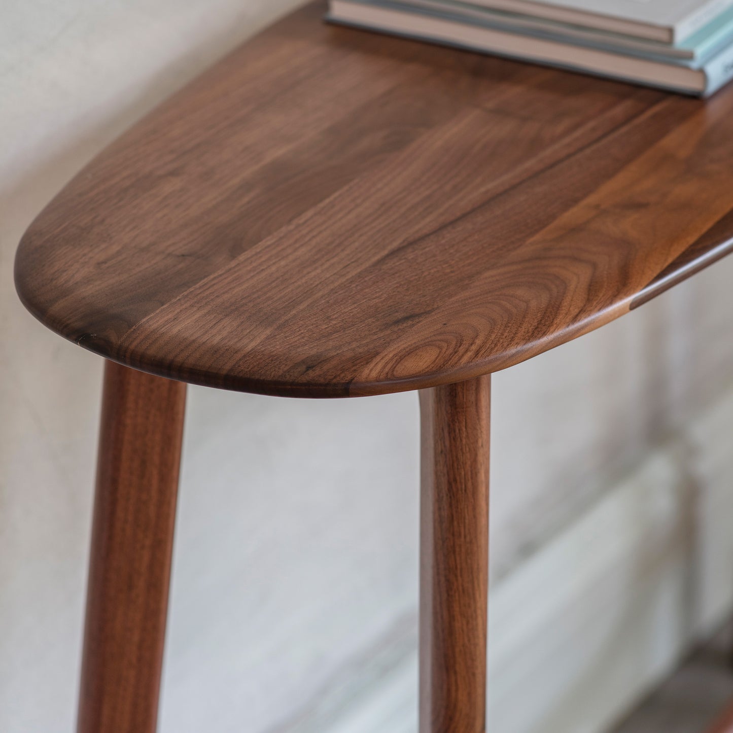 A Walnut Home Furniture Console Table with a book on it.
