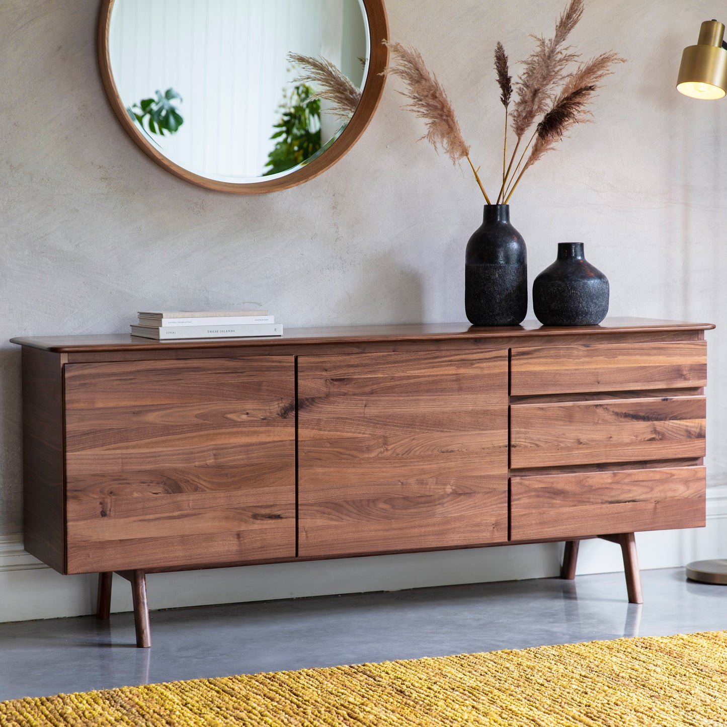 A Walnut Sideboard by Kikiathome.co.uk in a room with a mirror, enhancing the interior decor with its elegant design and functionality.