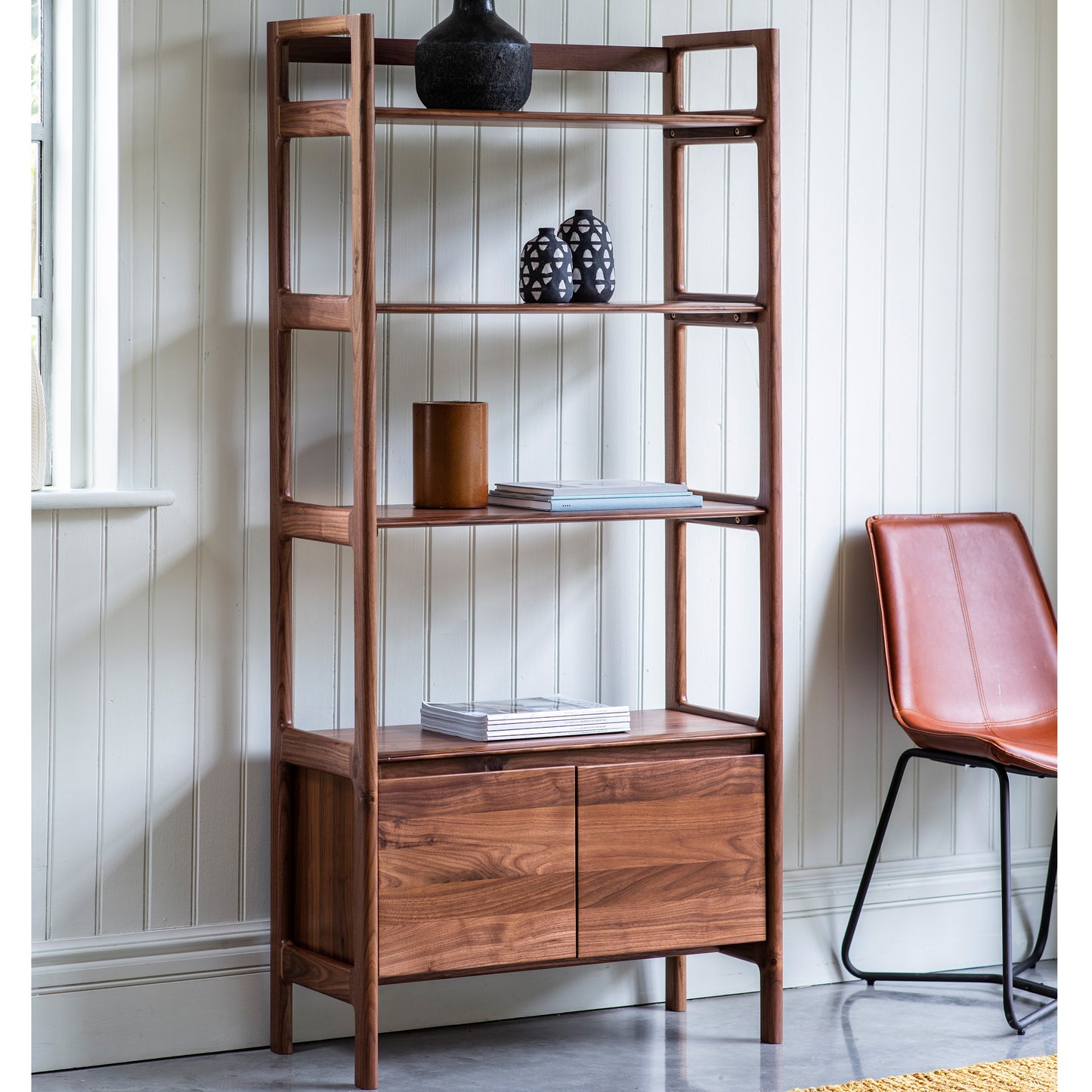 An interior decor bookcase from Kikiathome.co.uk in a room with an orange chair.