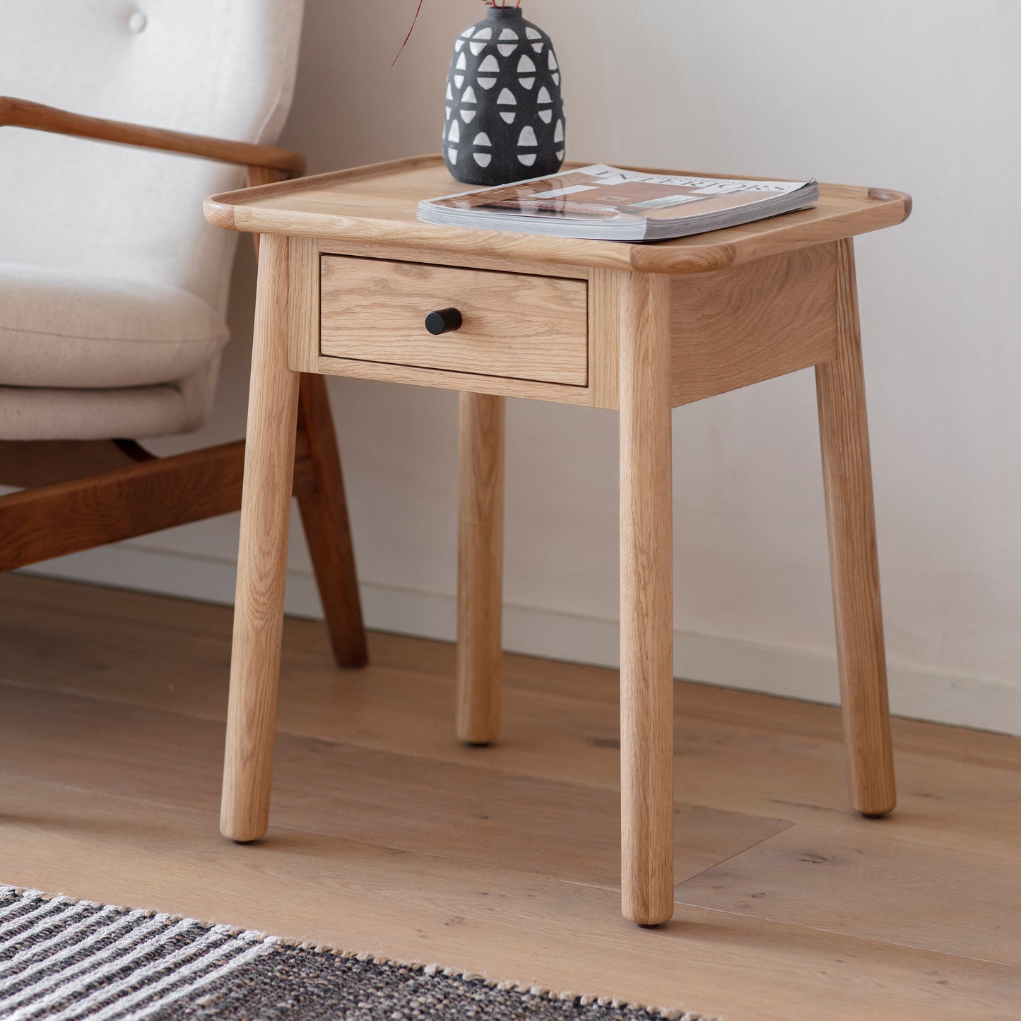 A small Wembury 1 Drawer Side Table 500x400x550mm from Kikiathome.co.uk with a book on it, perfect for home furniture and interior decor.