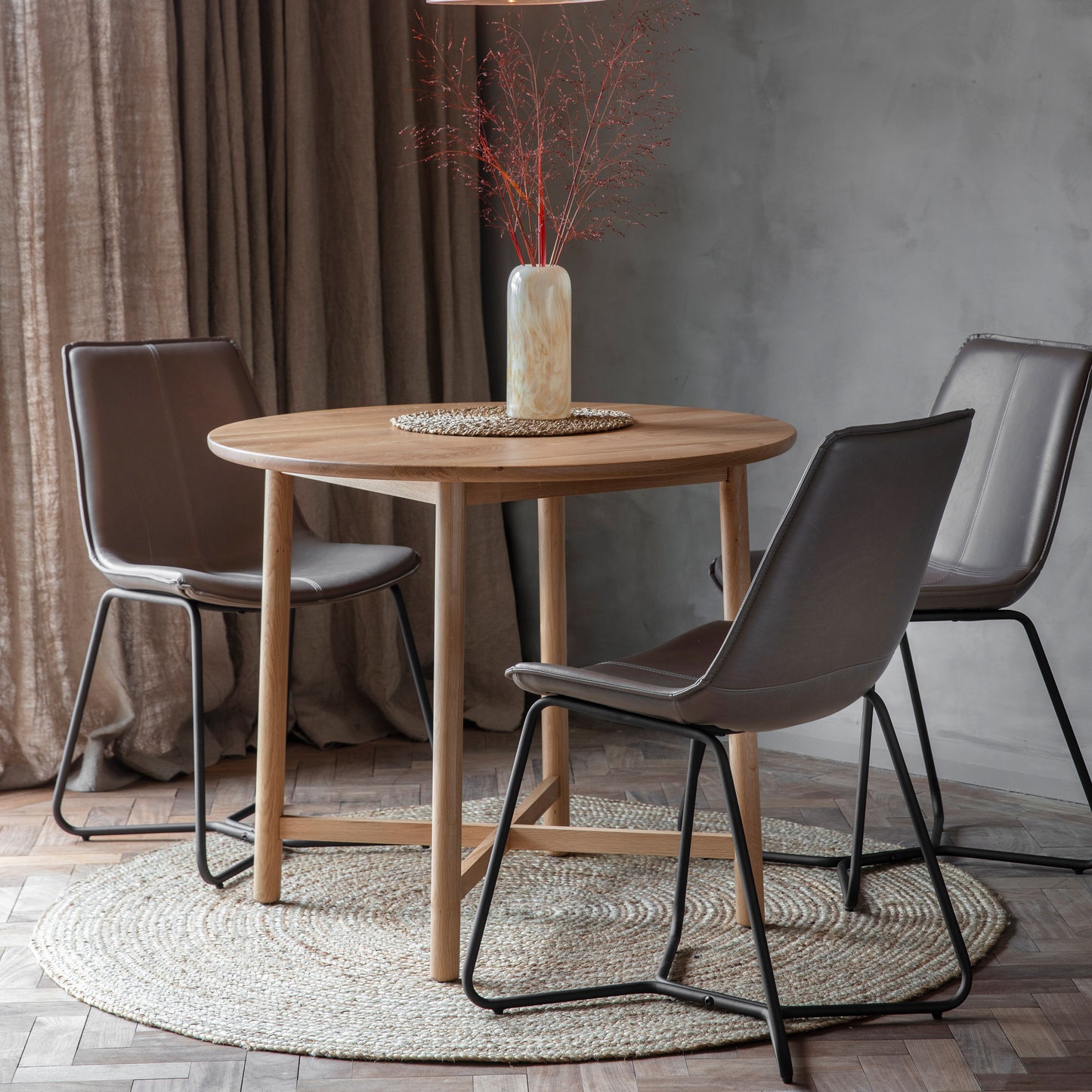 A Wembury Round Dining Table 900x900x750mm from Kikiathome.co.uk for home furniture and interior decor, with four chairs and a vase.