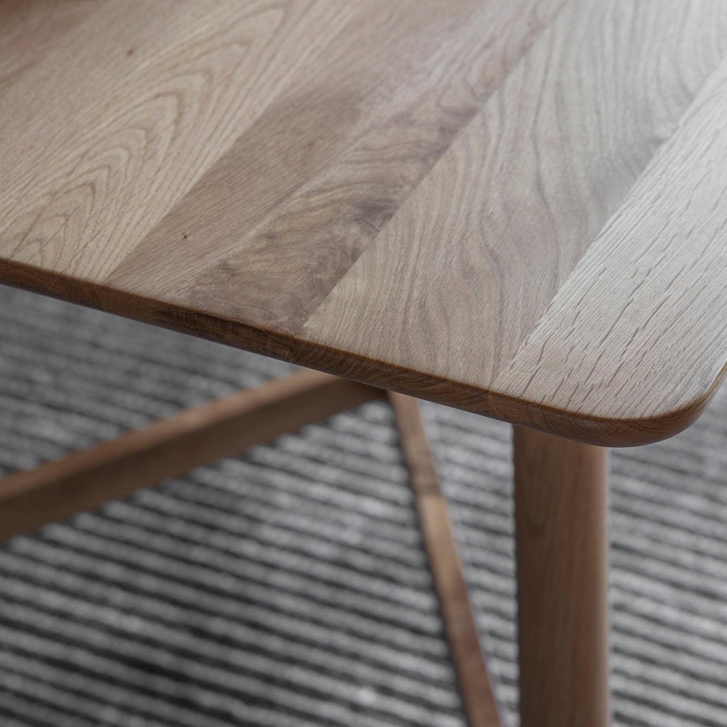 A close up of a Wembury Dining Table 1500x950x750mm by Kikiathome.co.uk on a rug, showcasing interior decor.