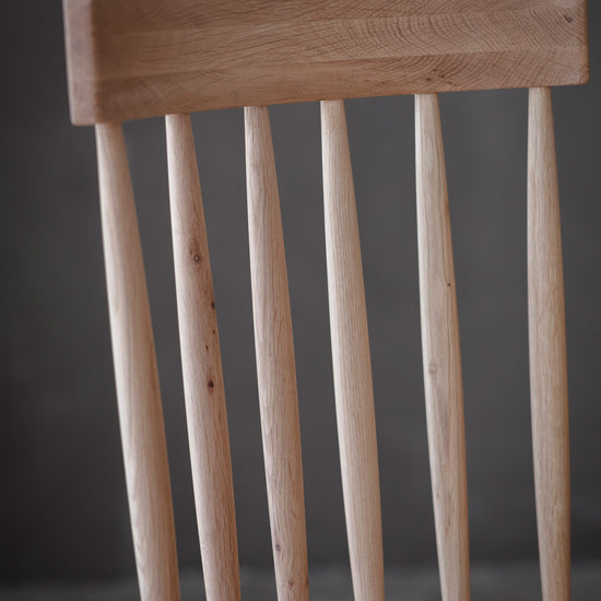 A close up of a Wembury Dining Chair with wooden legs, perfect for interior decor.