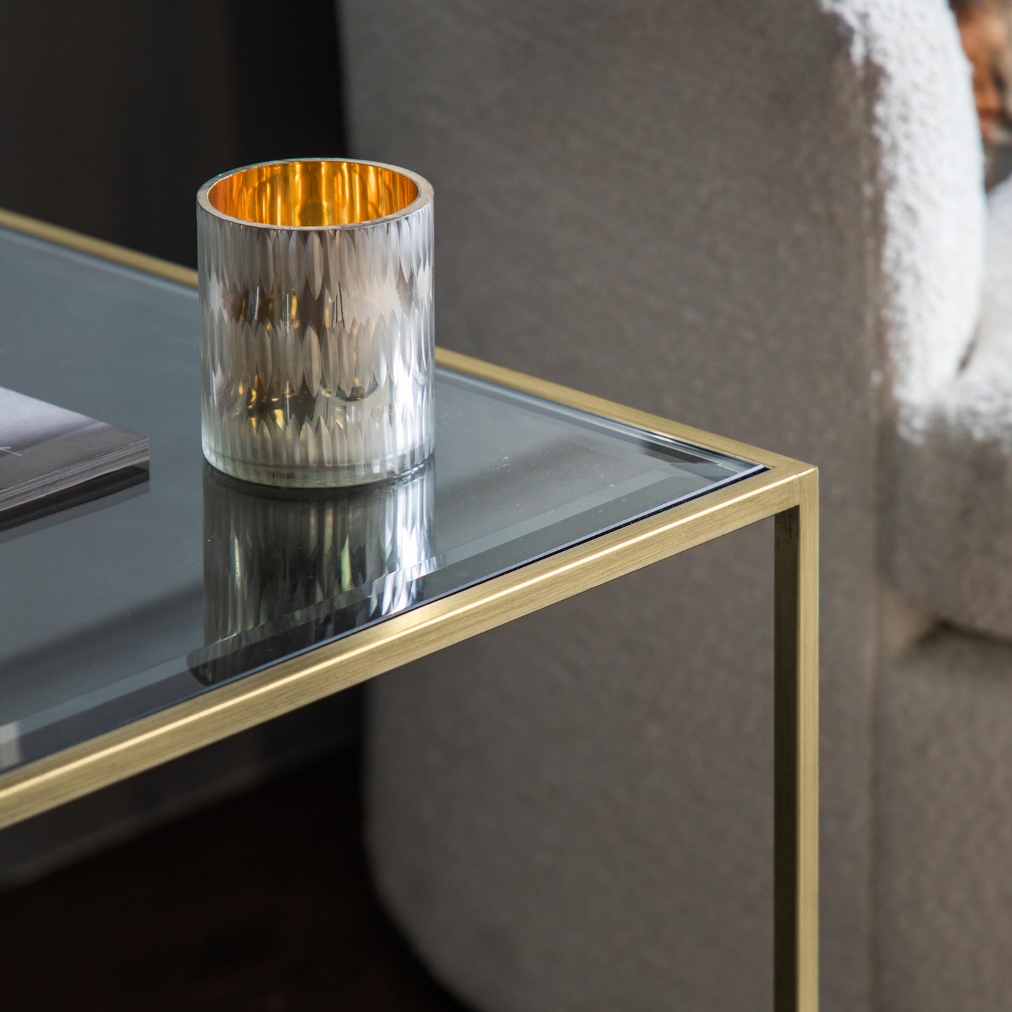 An interior decor side table from Kikiathome.co.uk featuring a champagne finish and dimensions of 500x500x550mm, adorned with a candle.