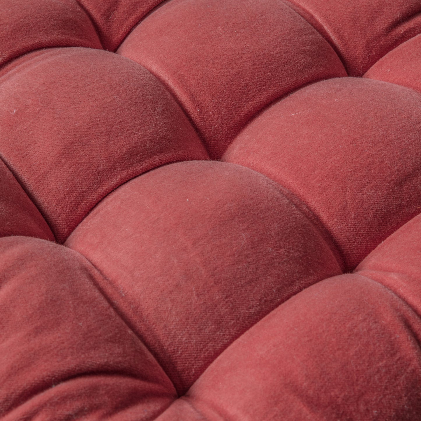 A close up of a Cotton Velvet Seatpad Coral 430x430mm for interior decor.
