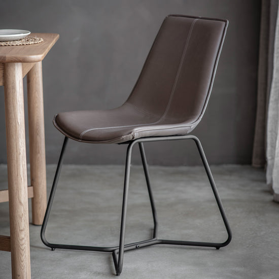 A Slapton Chair Brister (2pk) 490x550x860mm by Kikiathome.co.uk enhances interior decor alongside a wooden table.