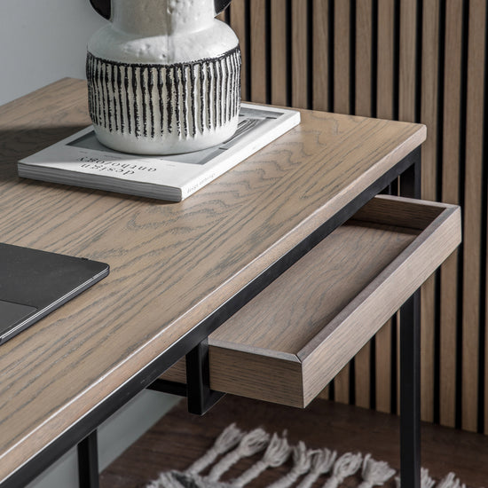 A Ringmore Desk Grey 1300x500x760mm with a laptop and a vase, ideal for interior decor and home furniture.