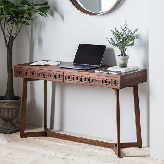 A stylish Dartington Retreat 2 Drawer Desk 1300x500x760mm from Kikiathome.co.uk perfect for home furniture and interior decor, complete with a laptop and mirror.
