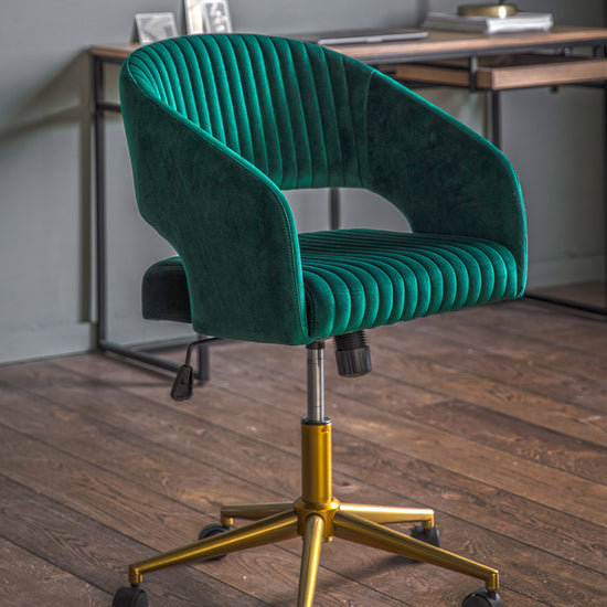 A green velvet Murray Swivel Chair adds a touch of luxury to any home's interior decor.