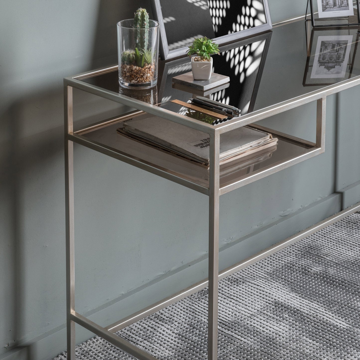 An Engleborne Desk Silver 1300x500x760mm with a glass top and a cactus, perfect for home furniture and interior decor.