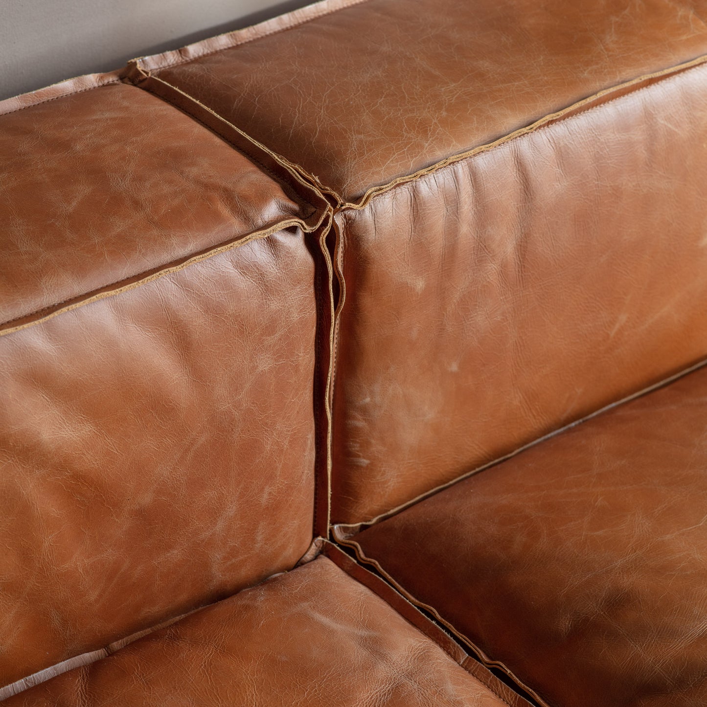 A close up of a Vintage Brown Leather couch from Kikiathome.co.uk, perfect for interior decor.