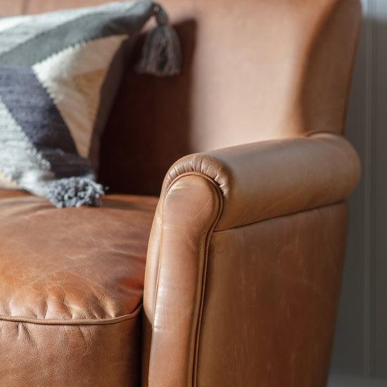 A close up of the vintage brown leather arm chair from Kikiathome.co.uk, perfect for home furniture and interior decor.