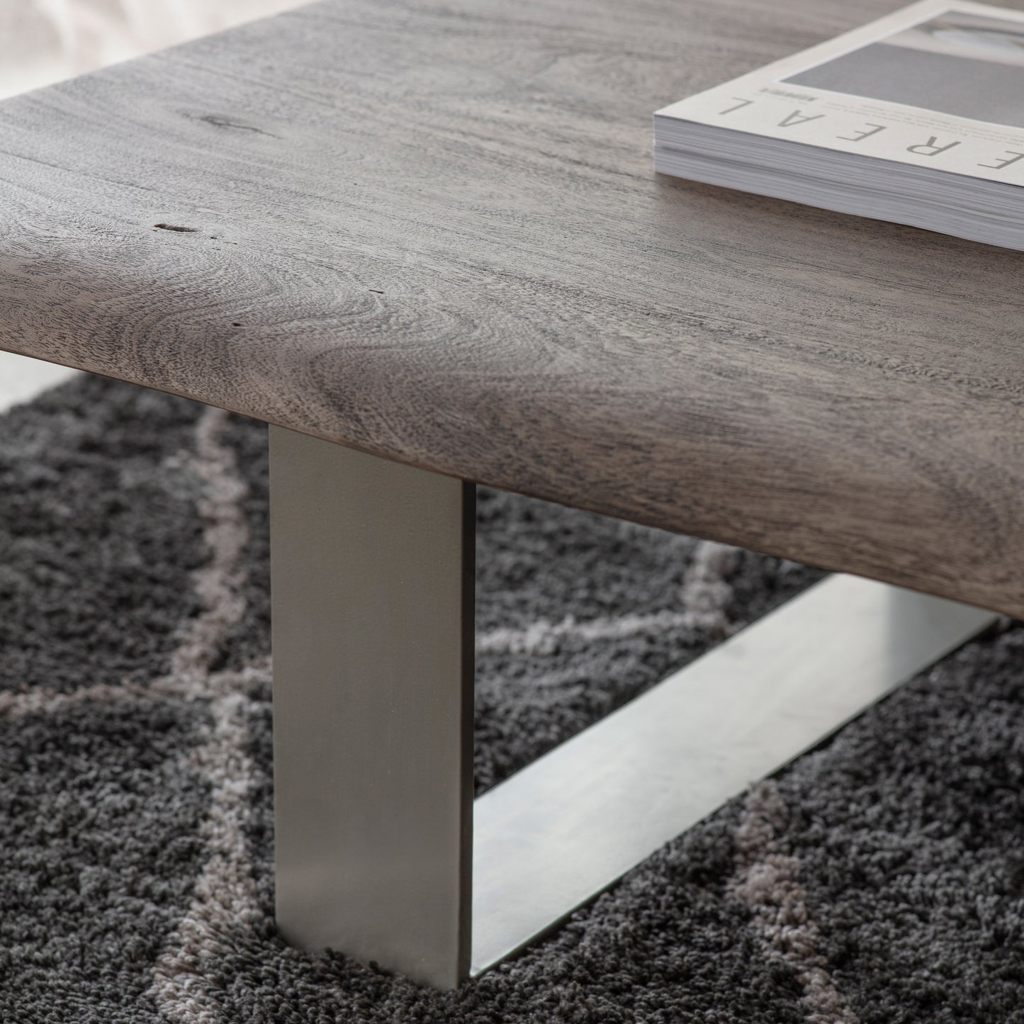 A Southpool Coffee Table with a metal base and a book on it, perfect for interior decor and home furniture.