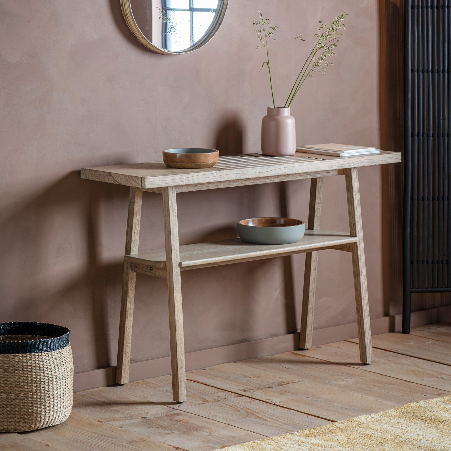 A sleek Alvington Console Table with mirror and basket, perfect for interior decor.