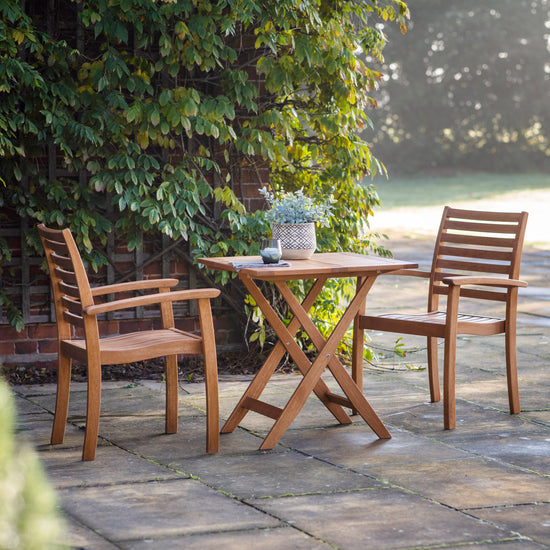 A Kikiathome.co.uk Manaton Outdoor Square Folding Table 700x700x730mm and chairs on a patio, perfect for outdoor home furniture.
