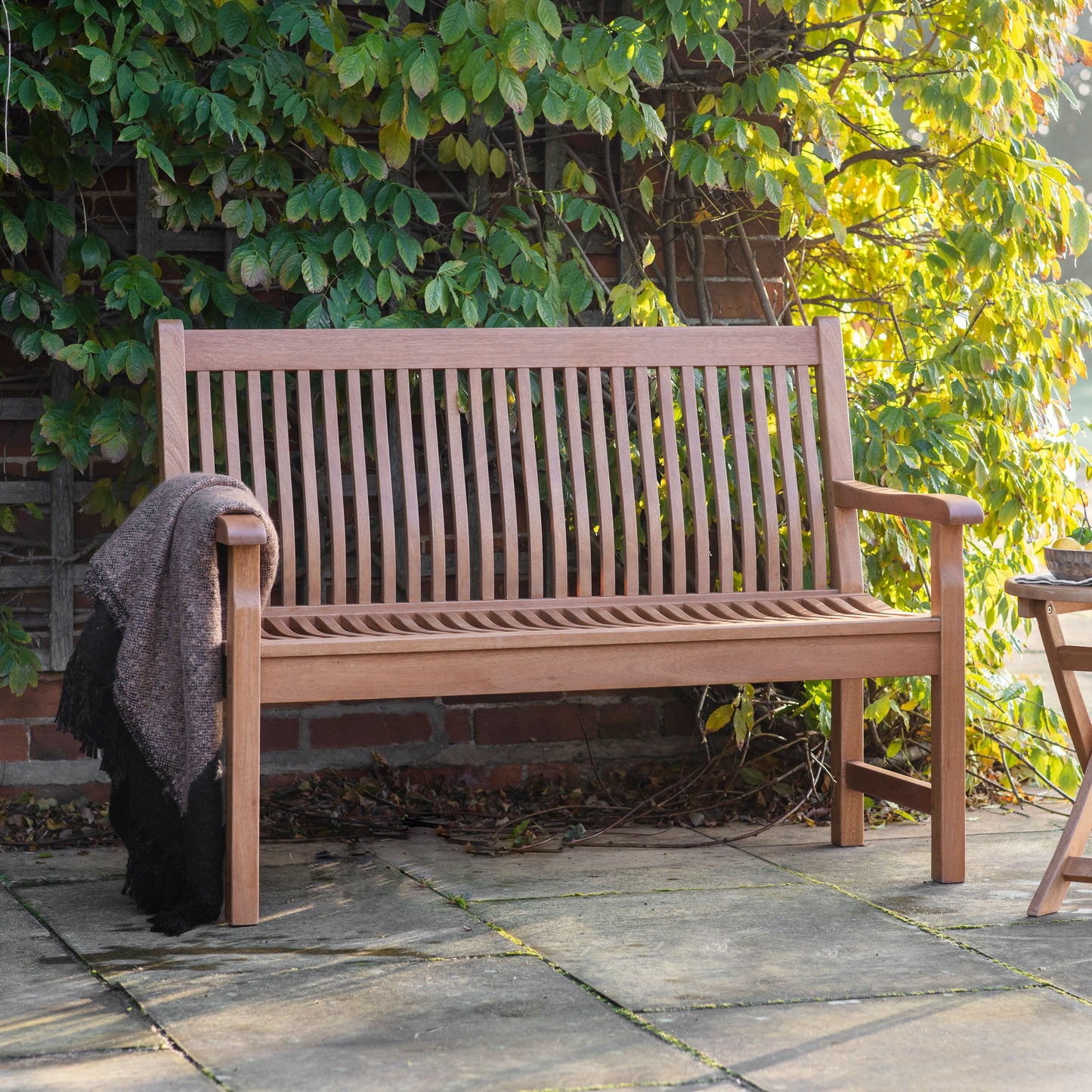 A Lustleigh Outdoor Bench with blanket, perfect for interior decor.