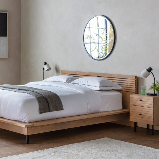 A Tortington wooden bed with a mirror frame, perfect for home furniture and interior decor.