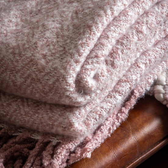 Load image into Gallery viewer, A Herringbone Faux Mohair Throw Blush 1300x1800mm with tassels on a wooden chair is part of the interior decor available at Kikiathome.co.uk
