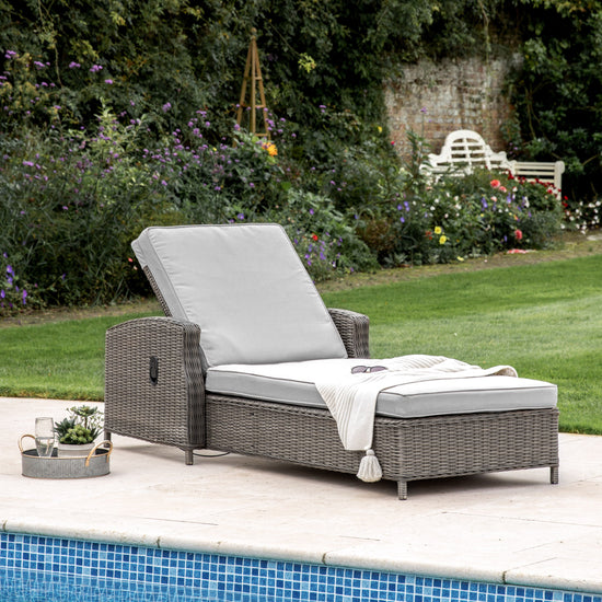 A Bigbury Sunlounger Grey, a perfect addition to your home furniture and interior decor, available at Kikiathome.co.uk next to a pool.