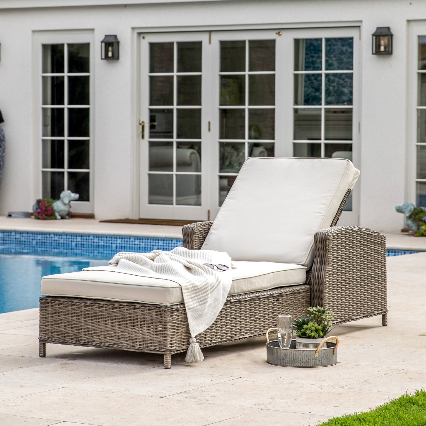 A Bigbury Sunlounger Natural by Kikiathome.co.uk, an interior decor addition for home furniture, placed alongside a pool.