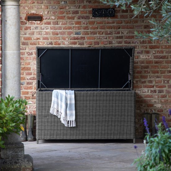 A home furniture storage box in grey from Kikiathome.co.uk on a brick patio.