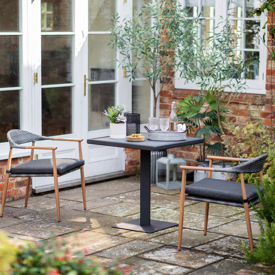 A Kilmington 2 Seater Bistro Set from Kikiathome.co.uk, perfect for interior decor and home furniture, on a patio.